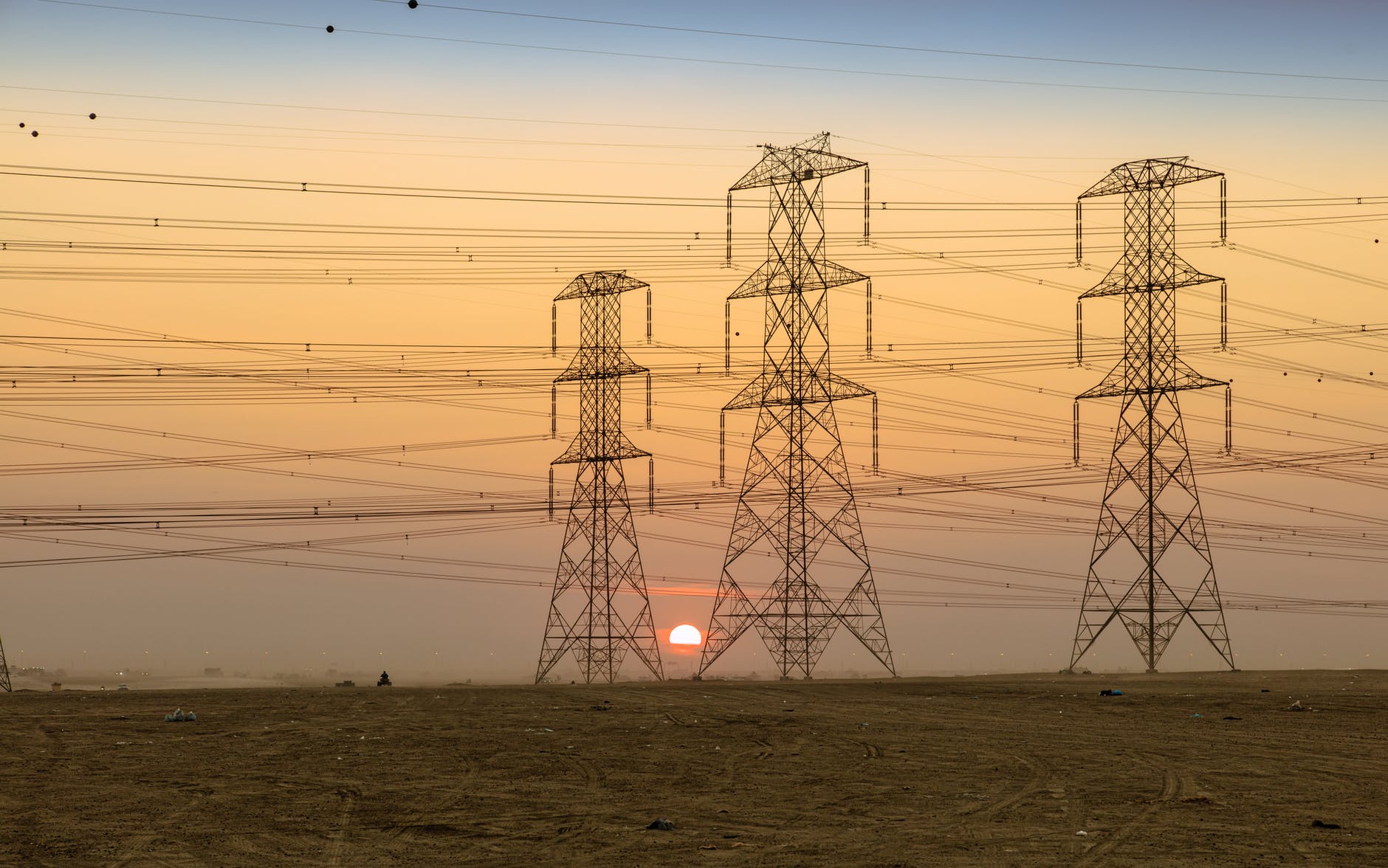 silhouette of electric towers during sunset